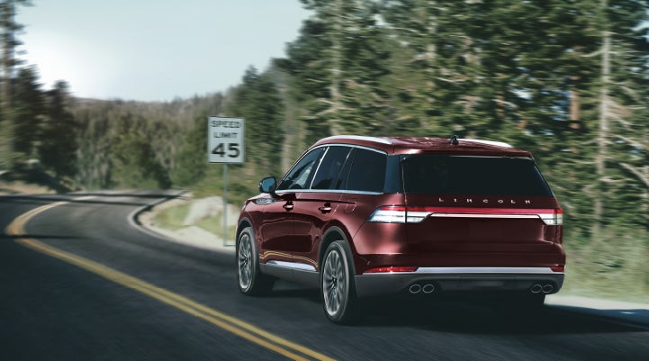 A 2024 Lincoln Aviator® SUV is being driven on a winding mountain road | Dorsch Lincoln in Green Bay WI