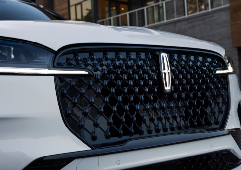 The black grille of a white 2025 Lincoln Aviator® SUV is shown with its fog lights on. | Dorsch Lincoln in Green Bay WI