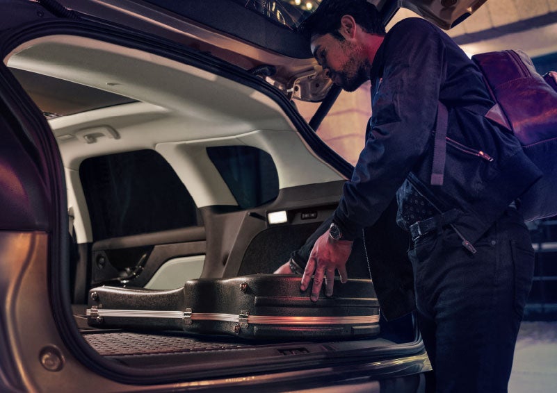A man is shown loading cargo into the rear of a 2024 Lincoln Corsair® SUV with the second-row seats folded flat. | Dorsch Lincoln in Green Bay WI