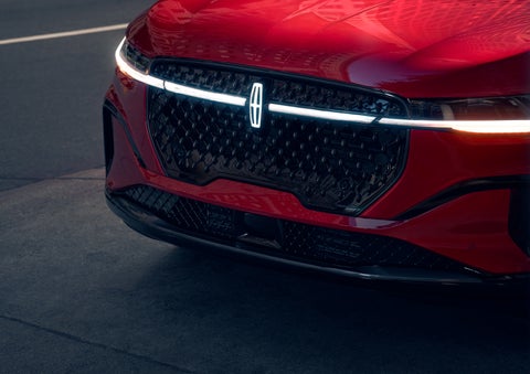 The available front LED light bar and center Lincoln Star logo glow at dusk. | Dorsch Lincoln in Green Bay WI