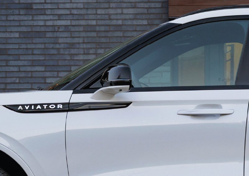 The driver’s side door and fender badging of a white 2026 Lincoln Aviator® SUV are showcased. | Dorsch Lincoln in Green Bay WI