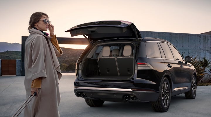 A woman approaches a 2026 Lincoln Aviator® SUV with its rear liftgate open. | Dorsch Lincoln in Green Bay WI