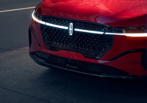 The available front LED light bar and center Lincoln Star logo glow at dusk. | Dorsch Lincoln in Green Bay WI