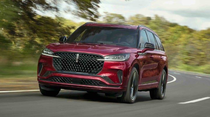 A 2027 Lincoln Aviator® SUV is being driven on a country road | Dorsch Lincoln in Green Bay WI